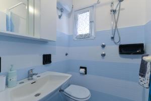 a blue bathroom with a toilet and a sink at Villa Oda - Bilocale sul mare in Capoliveri