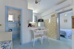 a small kitchen with a table and chairs in a room at Villa Oda - Bilocale sul mare in Capoliveri