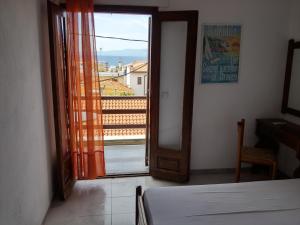 a bedroom with a door open to a balcony at Hotel Hellinikon in Ouranoupoli