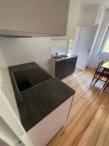 uma cozinha com uma bancada preta e piso em madeira em Spacious Apartment - green & peaceful em Liubliana