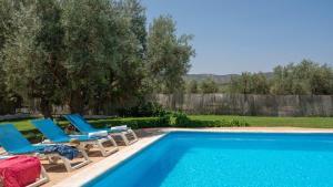 una piscina con 2 tumbonas y una piscina en Cortijo Alzamigaja Archidona by Ruralidays en Archidona