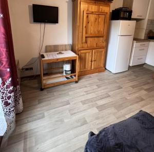 a kitchen with a wooden floor and a refrigerator at Studio avec balcon amenage a Praz sur Arly in Praz-sur-Arly