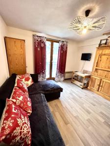 a living room with a couch and a tv at Studio avec balcon amenage a Praz sur Arly in Praz-sur-Arly