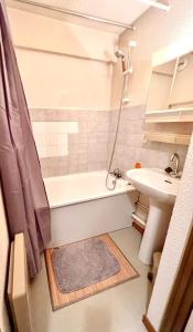 a small bathroom with a tub and a sink at Studio avec balcon amenage a Praz sur Arly in Praz-sur-Arly