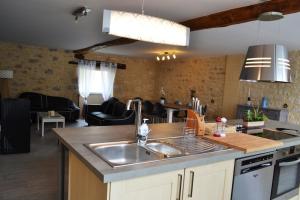 Una cocina con fregadero y una sala de estar. en Gîte la Forge 4 étoiles, en Monségur