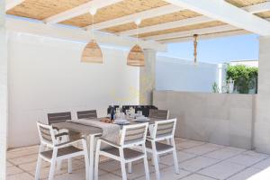 een eettafel en stoelen op een patio bij TD Villa Patrizia Pool & Alfresco Kitchen in Monopoli