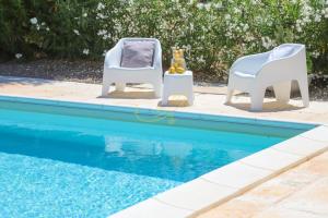 twee stoelen naast een zwembad bij TD Villa Patrizia Pool & Alfresco Kitchen in Monopoli