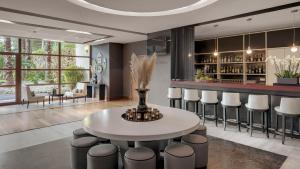 a dining room with a white table and stools at Precise Resort El Rompido-The Hotel in El Rompido