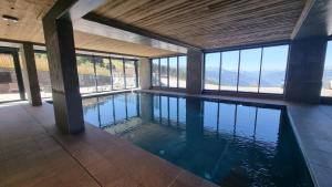 a swimming pool in a house with windows at Ridge302 in Bourg-Saint-Maurice