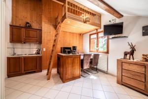 a kitchen with wooden cabinets and a table with chairs at Au Rêve Savoyard 6 - 4 personnes in Morillon