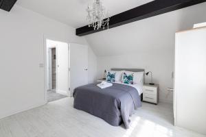 a white bedroom with a bed and a chandelier at Elegant 1BR Apartment, Sleeps up to 4 in Childwall