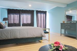 a bedroom with a bed and a dresser and a mirror at Le Tropical, Chic & Design in Wahlbach