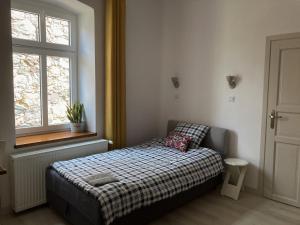 a small bedroom with a bed and a window at Farma Jamienko in Jamienko