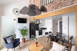 Il comprend un salon avec une table et des chaises ainsi qu'une cuisine. dans l'établissement Le Saint Martin Bis - Bel appartement moderne et confortable, à Rennes