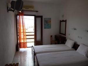 una camera con due letti e una grande finestra di Hotel Hellinikon a Ouranoupoli
