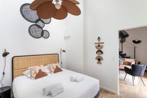 - une chambre avec un lit blanc et un ventilateur de plafond dans l'établissement Le Saint Martin Bis - Bel appartement moderne et confortable, à Rennes