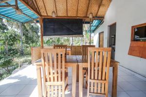 - une salle à manger avec une table et des chaises en bois dans l'établissement Penida Lapaya Bungalows Nusa Penida, à Nusa Penida