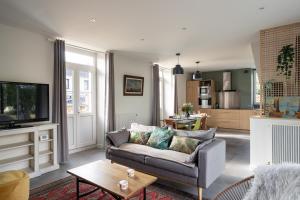 a living room with a couch and a tv at La Maison Du Verger - 4 chambres aux portes de Rennes in Saint-Jacques-de-la-Lande