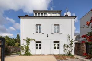 a white house with a tower on top of it at La Maison Du Verger - 4 chambres aux portes de Rennes in Saint-Jacques-de-la-Lande