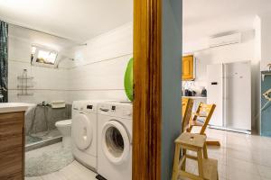 a bathroom with a washing machine and a toilet at Nice central family apartment in Gastoúni