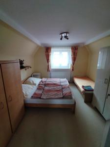 a small bedroom with a bed and a window at Apartmán se zahradou in Krnov