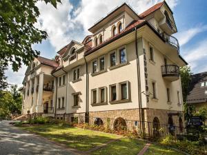 a large white building on the side of a street at VisitZakopane - Radowid Loft Spa Apartment in Zakopane