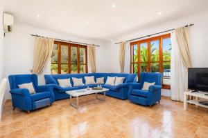a living room with blue couches and a tv at Pomeres Nou in Sa Coma