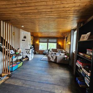 salon z drewnianymi sufitami i kanapą w obiekcie Bjørnebu- Ski in-ski out w mieście Kvam