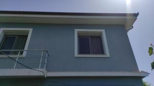 a blue building with a balcony on the side of it at Guesthouse Isolde in Vlorë