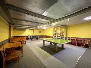 Cette chambre comprend une table de ping-pong et des chaises. dans l'établissement Pied de piste de Thyon - 4 Vallees, à Vex