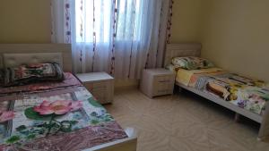 a room with two beds and two tables in it at Guesthouse Isolde in Vlorë