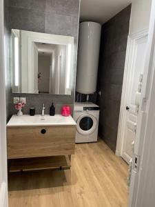 łazienka z umywalką i pralką w obiekcie Appartement T4 centre-ville w mieście Soissons