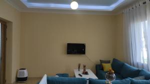 a living room with a blue couch and a tv at Guesthouse Isolde in Vlorë