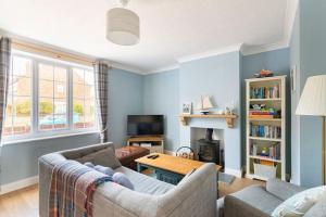 ein Wohnzimmer mit Sofa und Tisch in der Unterkunft Nina's Cottage - Southwold in Southwold