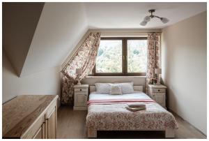 a bedroom with a bed and a window at Dom Malowany Wetlina in Wetlina