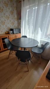 einen Tisch und Stühle in einem Zimmer mit Fenster in der Unterkunft Celtnieku 14 in Ventspils