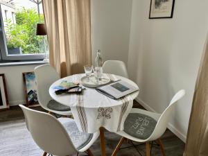 a white dining room table with chairs and a book on it at Gästehaus Grüne Oase in Fulda +8 photos