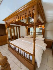 a large wooden canopy bed in a room at Kuwait Palace Hotel in Kuwait