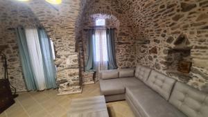 um quarto com um sofá numa parede de pedra em Olympus em Olýmpoi