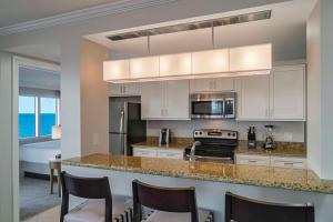 a kitchen with white cabinets and a counter with chairs at Hyatt Regency Clearwater Beach Resort & Spa in Clearwater Beach