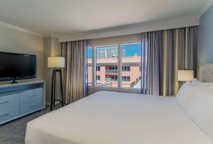 Habitación de hotel con cama grande y ventana grande. en Hyatt Regency Clearwater Beach Resort & Spa, en Clearwater Beach