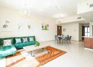 a living room with a green couch and a table at RH- Escape to Golf View, 03BR with large Terrace, Greens in Dubai