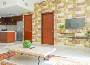 a living room with a table and a tv on a wall at RH- Escape to Golf View, 03BR with large Terrace, Greens in Dubai