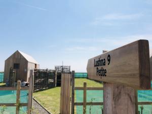 a wooden sign on a fence with a barn at Lushna 8 Petite at Lee Wick Farm Cottages and Glamping in Clacton-on-Sea +2 photos