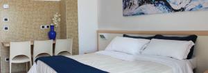 un dormitorio con una cama con un jarrón azul al lado en Residence Ada, en Grottammare