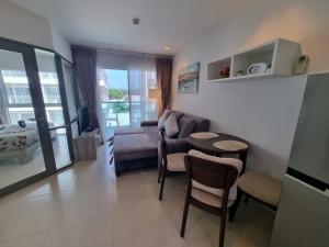 a living room with a couch and a table at Grandblue condominium 301 in Ban Tha Fat