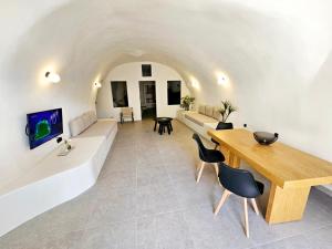 Petroma Cave Suites في Vourvoúlos: غرفة معيشة مع أريكة وطاولة