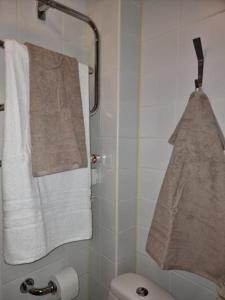 a bathroom with white towels hanging on a wall at Cosy Apartment in heart of Stockholm Sweden in Stockholm