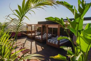 a room with four beds on a deck with plants at Nobu Hotel Barcelona in Barcelona