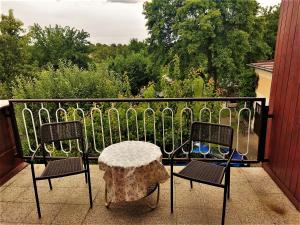 a patio with two chairs and a table on a balcony at Apartmán se zahradou in Krnov